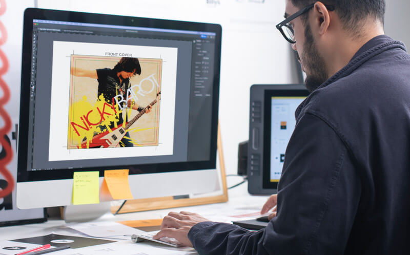 Independent musician comparing album cover maker tools and DIY design options